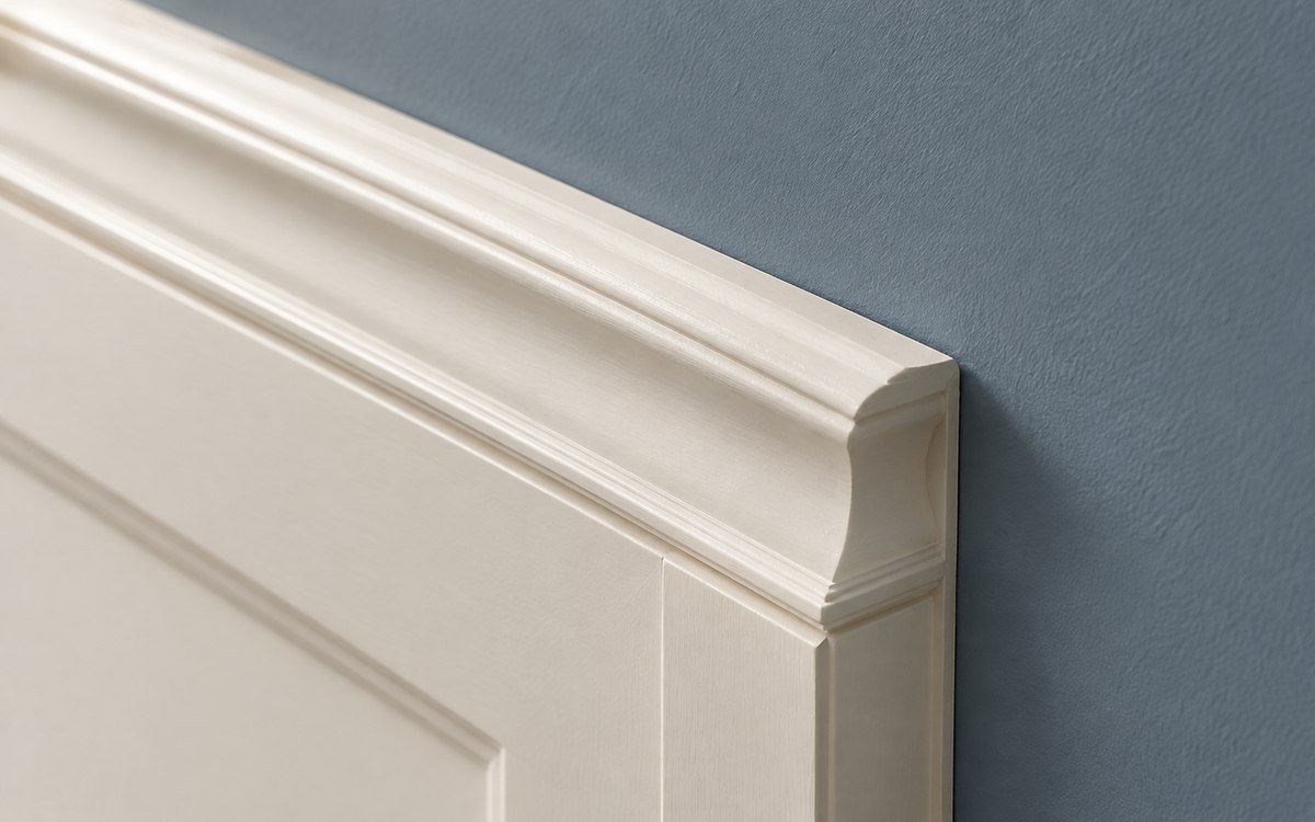 Détail d’une moulure peinte blanc cassé au contact d’un mur bleu-gris