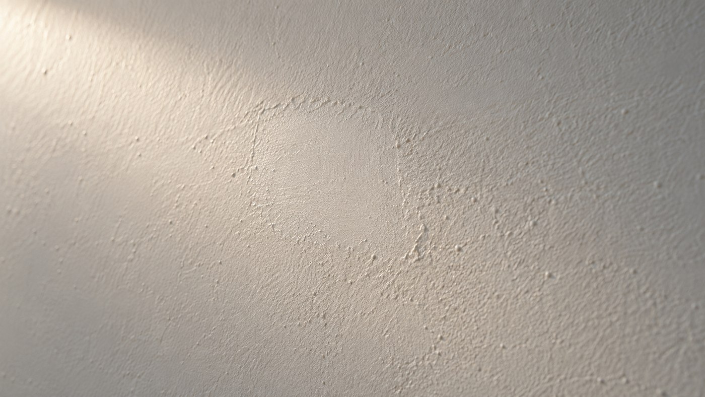 Lumière rasante sur un mur blanc cassé révélant une légère reprise de surface