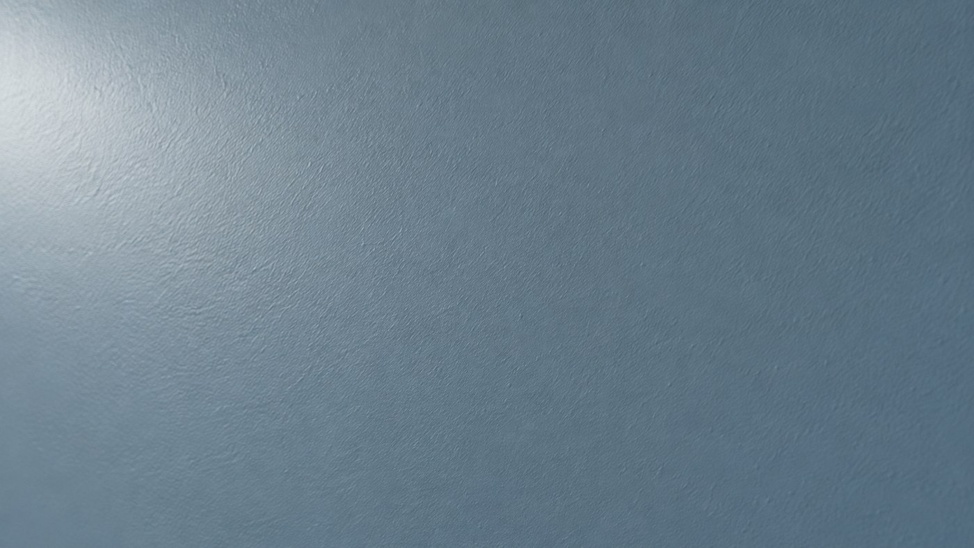 Surface peinte bleu-gris velours avec un reflet doux sous lumière latérale